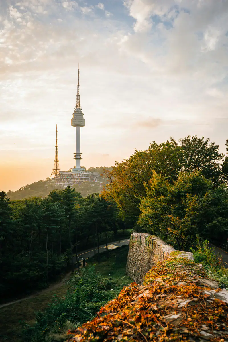 Namsan Tower above a wooded hill and the old stone wall — Namsan, Seoul
