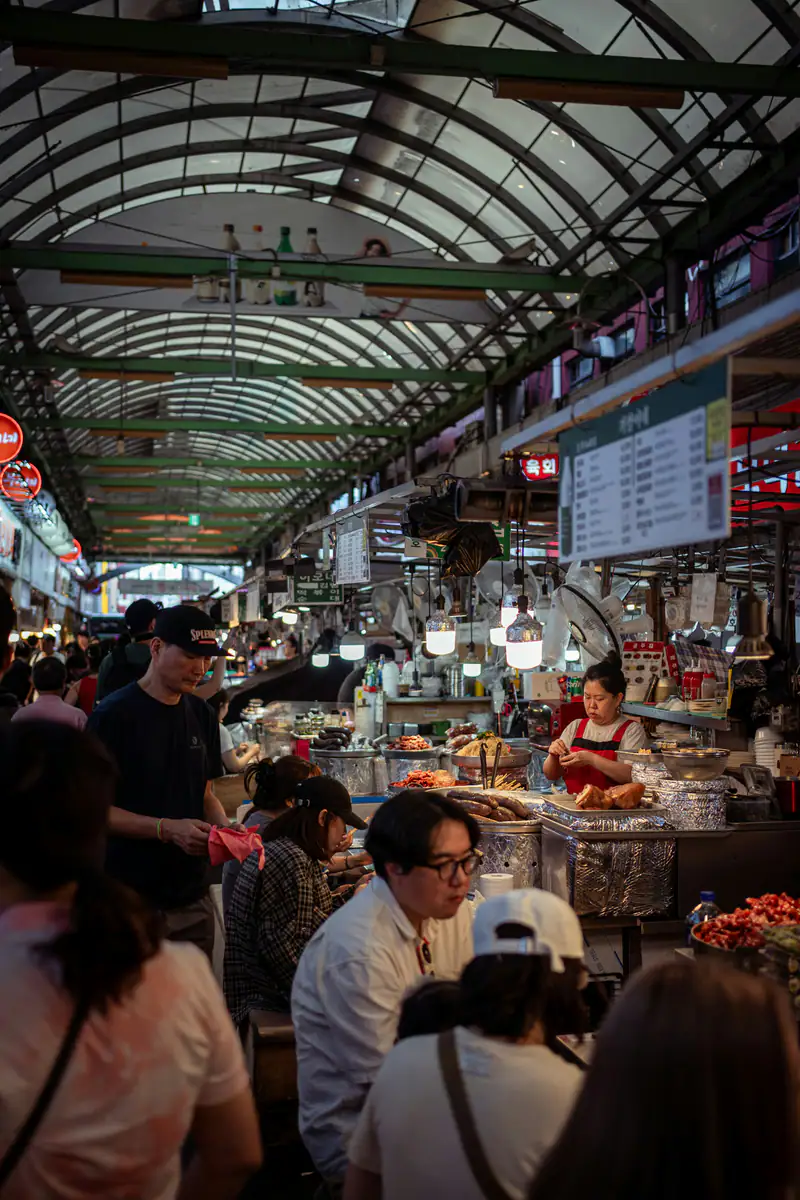 A crowded aisle of food stalls — Gwangjang Market, Seoul